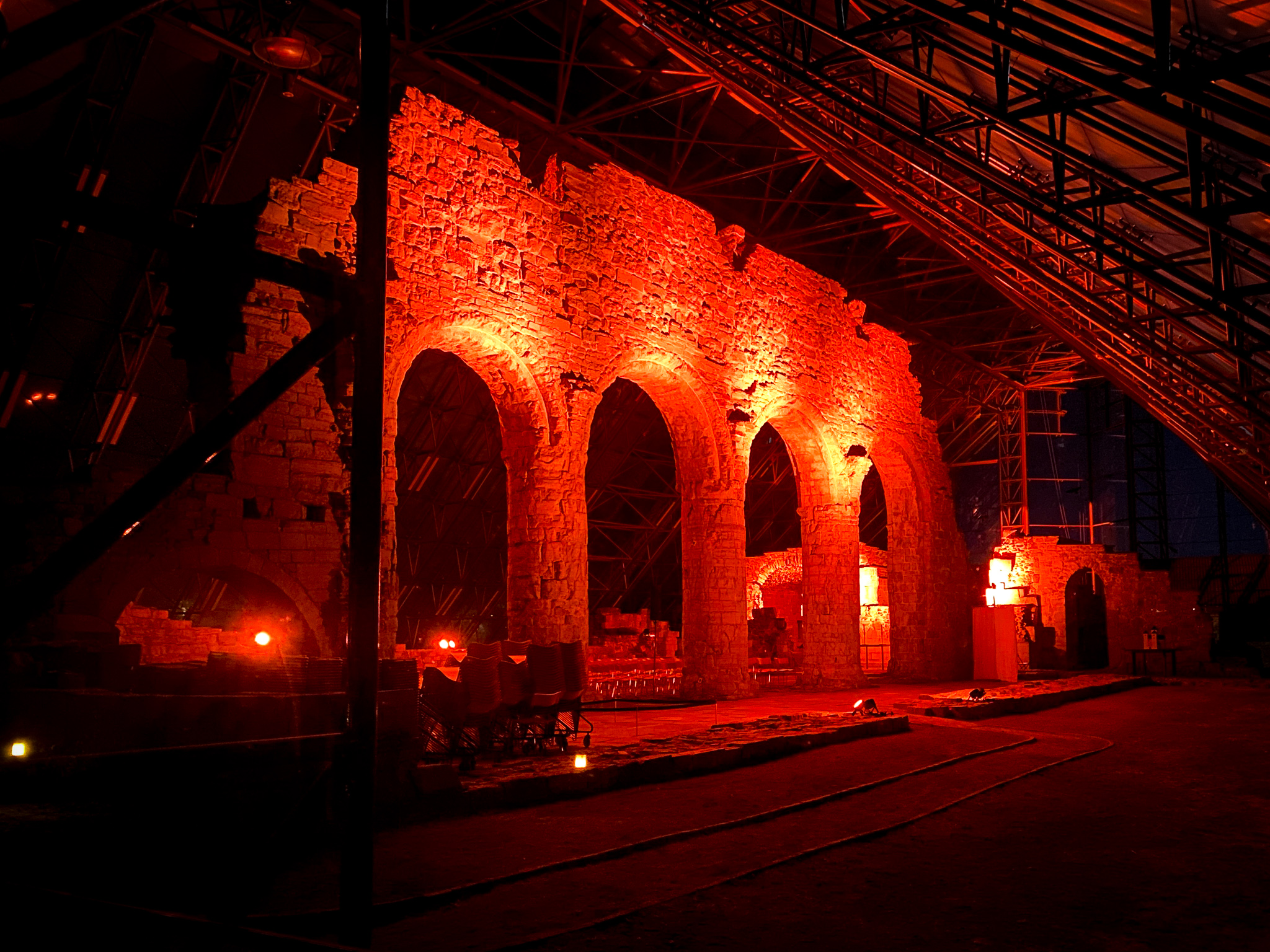 Domkirkeruinene i Hamar lyst opp med oransje lys.