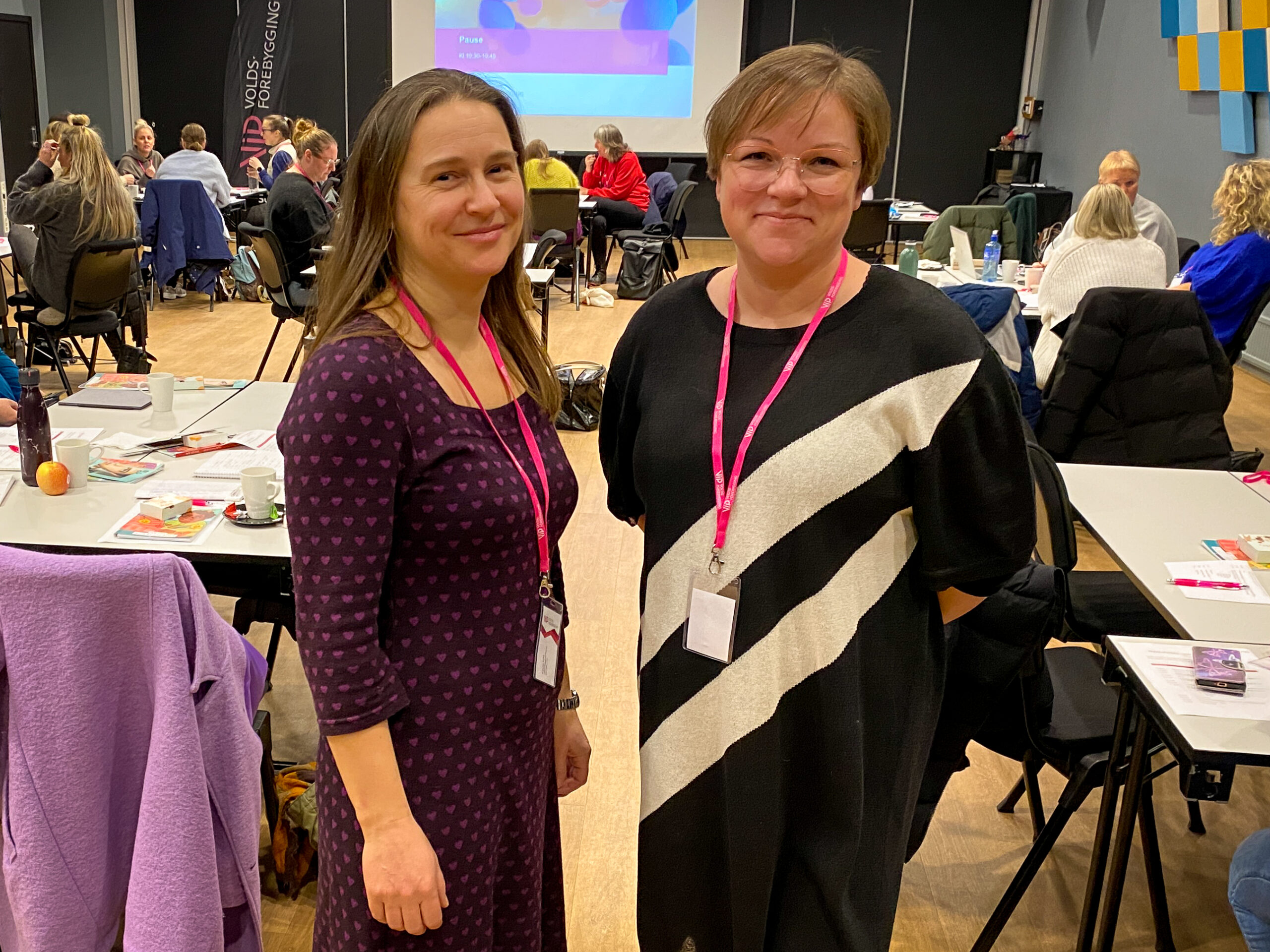 Frøydis og Annette står sammen. De smiler og ser i kamera.