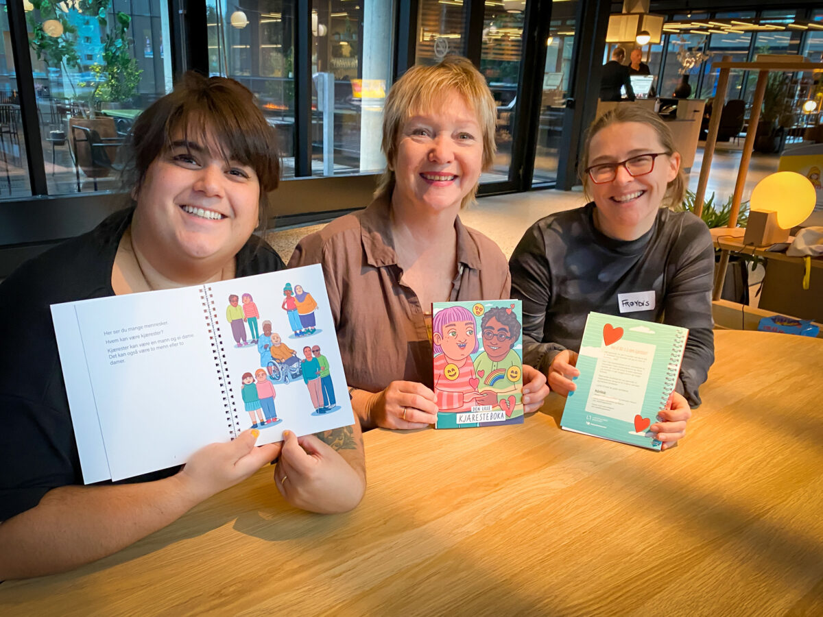
			Carina, Wenche og Frøydis holder hvert sitt eksemplar av «Den lille kjæresteboka».			