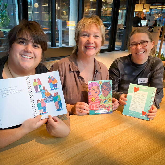 Carina, Wenche og Frøydis holder hvert sitt eksemplar av «Den lille kjæresteboka».