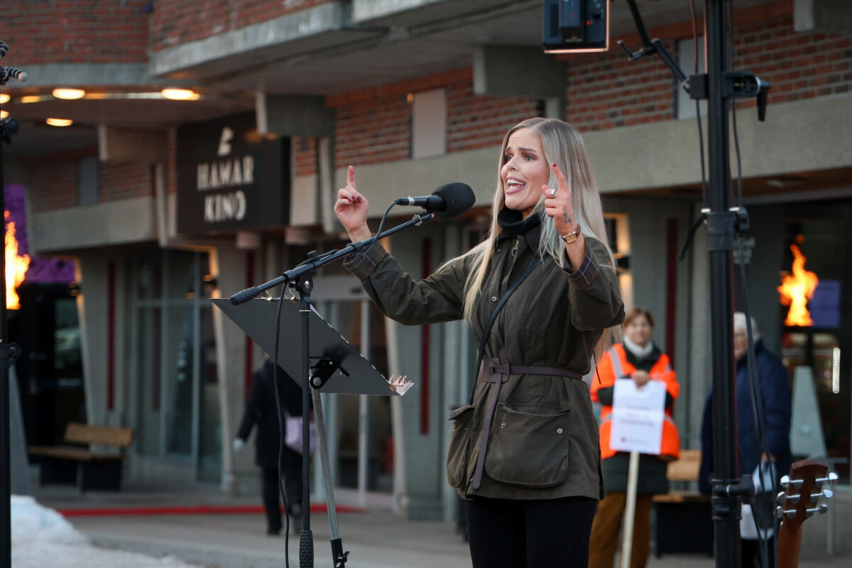 8. mars-tog. Christina Eden Jønsson står foran mikrofon og taler til forsamlingen.