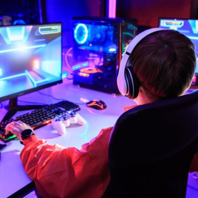 Gamer spiller dataspill i et fargerikt gaming-setup.