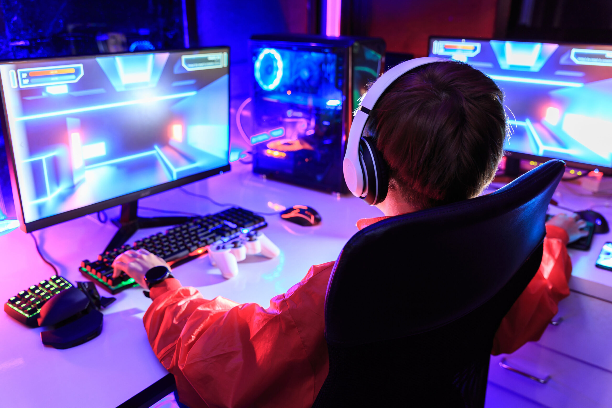 Gamer spiller dataspill i et fargerikt gaming-setup.