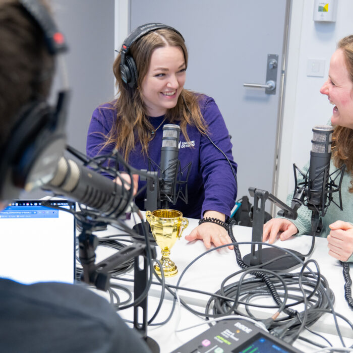 Ida Dorthea Wiken Brandt og Kristina Miklavic i podkaststudio. Ida og Kristina ser på hverandre. VI ser bakhodet til programleder Tom Andreas Kristensen.