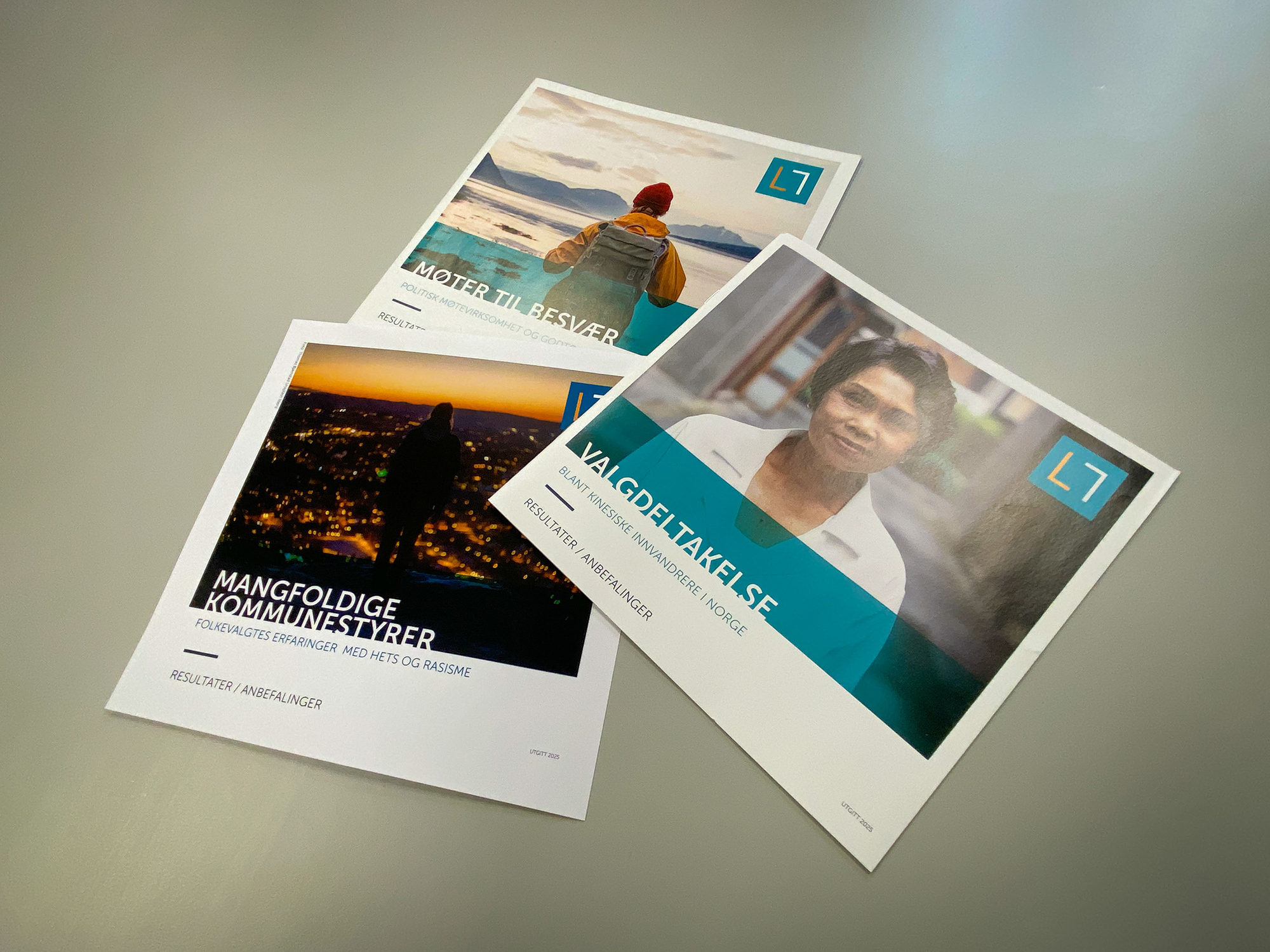 Tre brosjyrer ligger sammen på et bord.