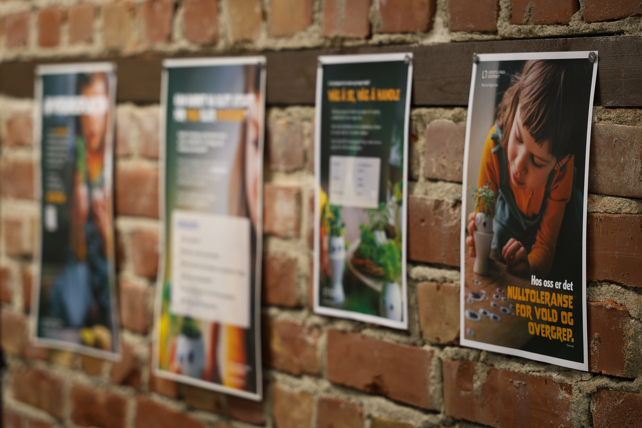 Fire plakater henger på en vegg.