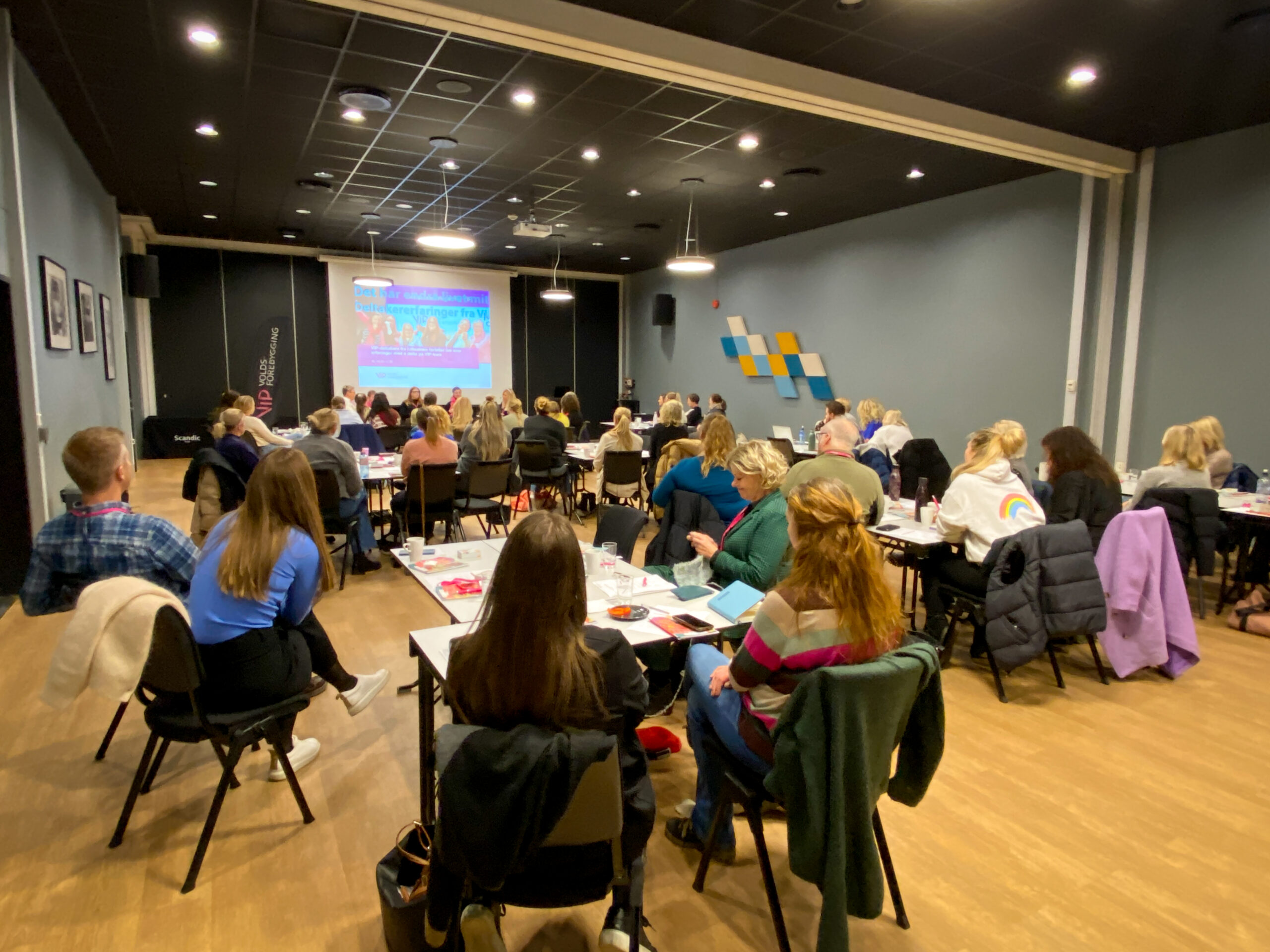 Et konferanserom fullt av mennesker.