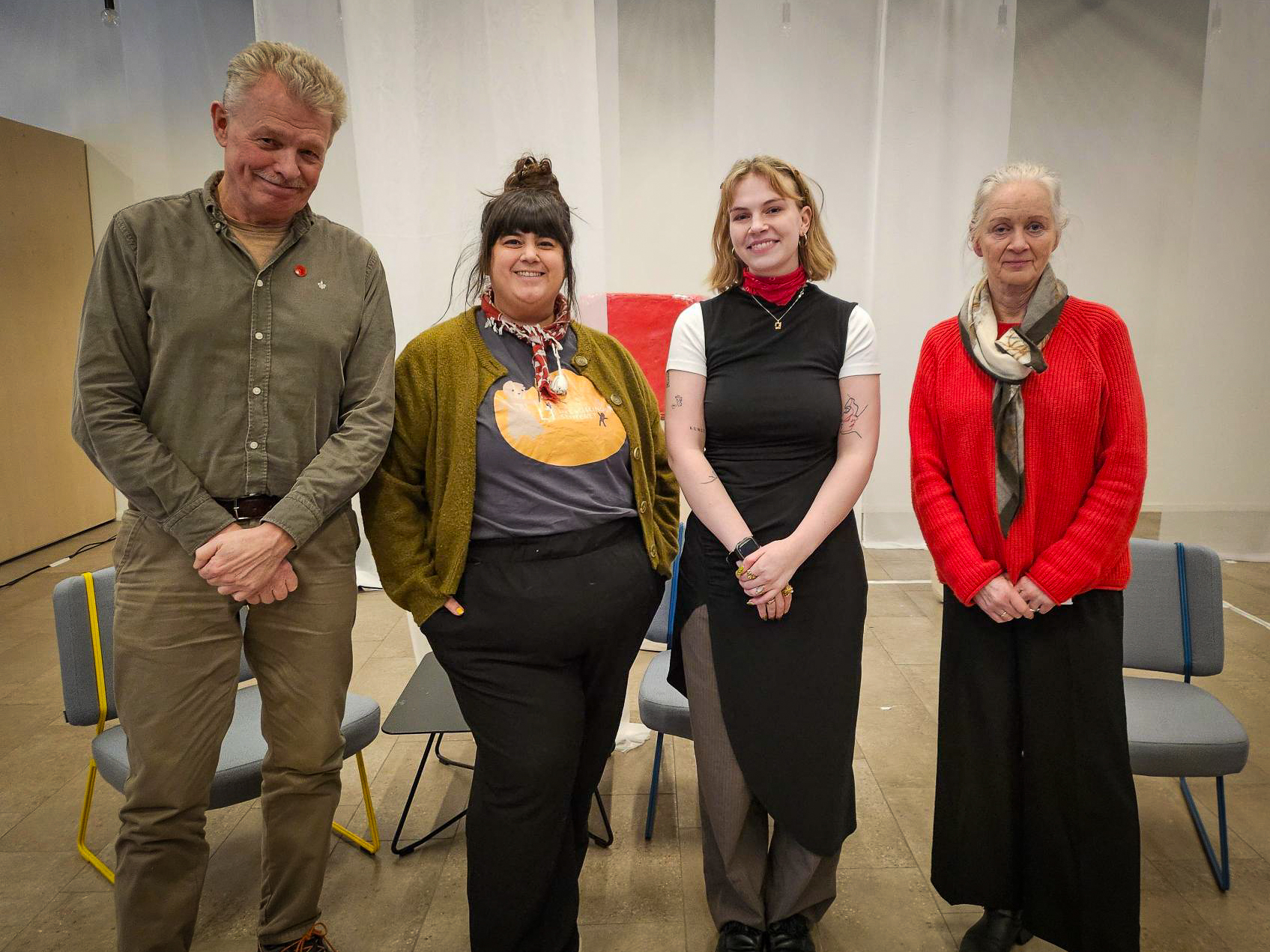 Fire personer på rekke, alle ser i kamera.